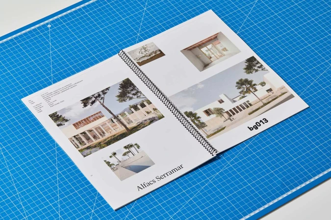 Open magazine spread displaying architectural photography on a blue cutting mat, showcasing modern building designs.
