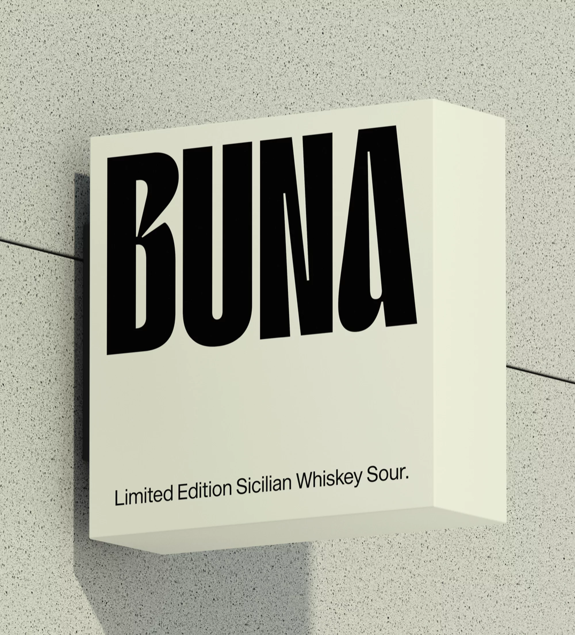Black BUNA text on a square ivory sign attached to a speckled grey wall, promoting a Limited Edition Sicilian Whiskey Sour.