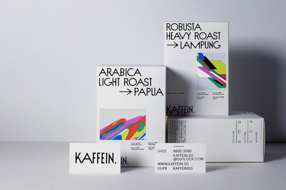Kaffein brand of Arabica light roast and Robusta heavy roast coffee beans in white cardboard boxes against white background.