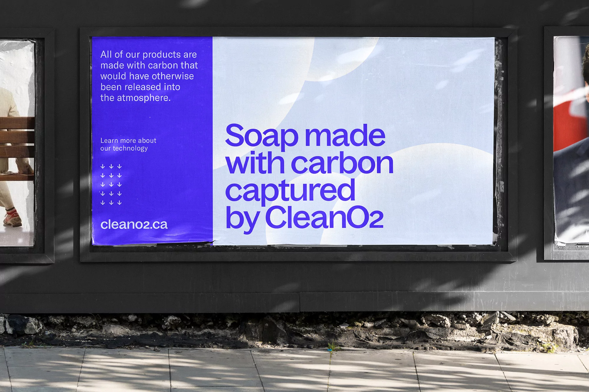 CleanO2 billboard advertisement featuring text about carbon capture and soap, set on a wall with environmental elements visible.