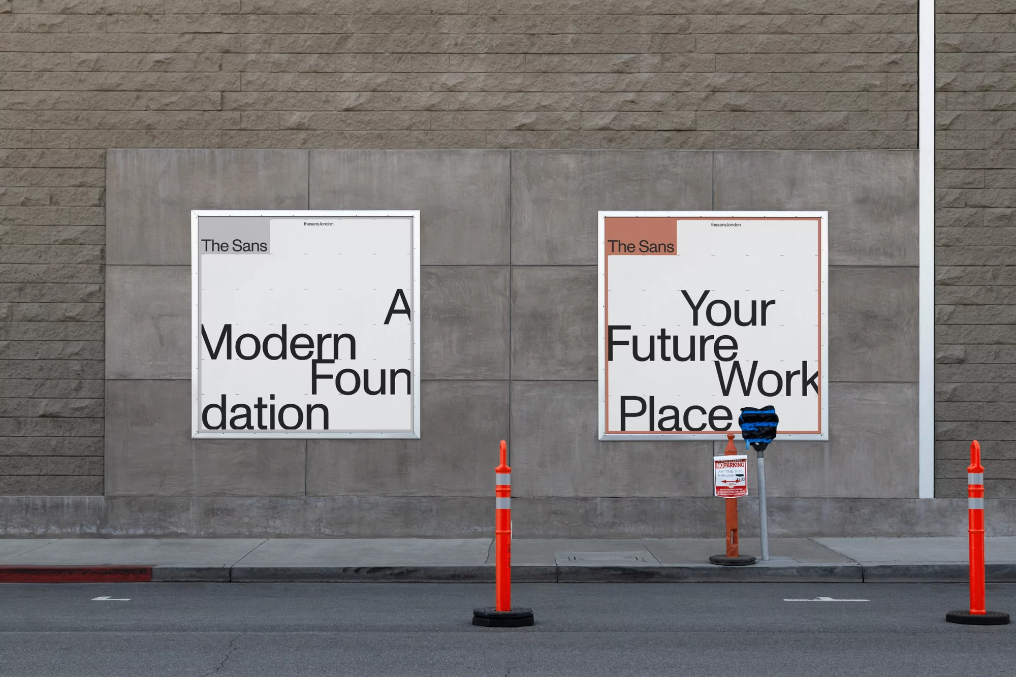 Two white posters with black text on a gray wall in an urban setting, promoting 'The Sans' with modern design and placement concepts.