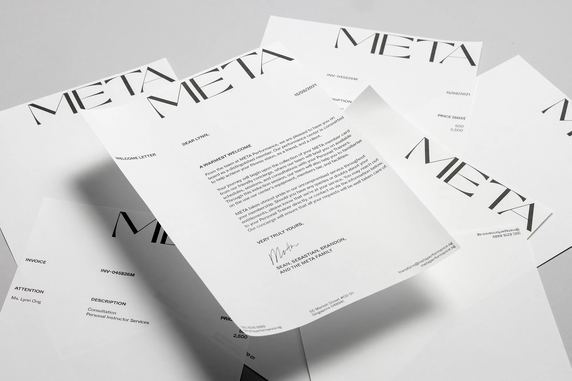 Multiple Meta branded welcome letters and invoices are scattered on a light gray surface, with various fonts and document layouts.