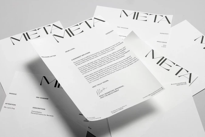 Multiple Meta branded welcome letters and invoices are scattered on a light gray surface, with various fonts and document layouts.