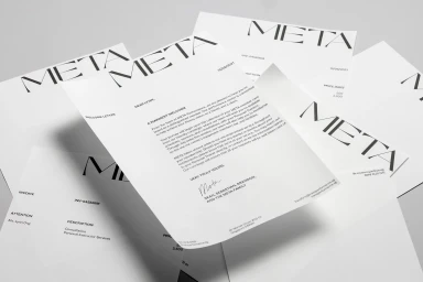 Scattered white letterhead stationery featuring bold black typography with the word META against a clean neutral background
