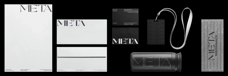 A flat lay of corporate stationery and branded merchandise featuring the META Performance logo on a solid black background.