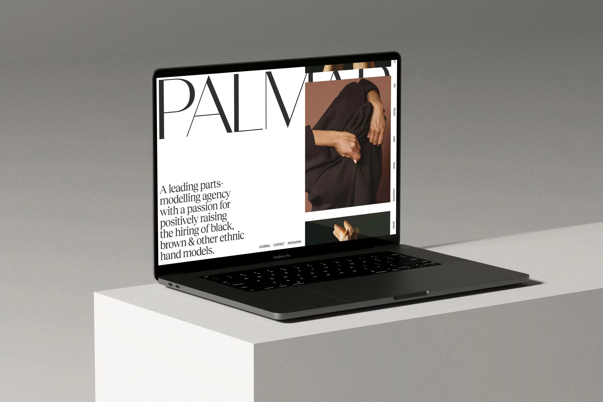 Laptop displays a website for Palm, a modeling agency, showcasing diverse hand models. The laptop sits on a white surface with gray background.