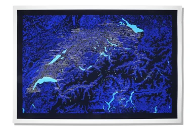 A detailed blue and black topographical map print featuring typography and water features mounted against a white studio background.