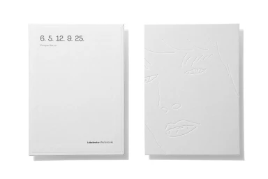 Two white notebooks with embossed line art and typography displayed flat on a clean white background.