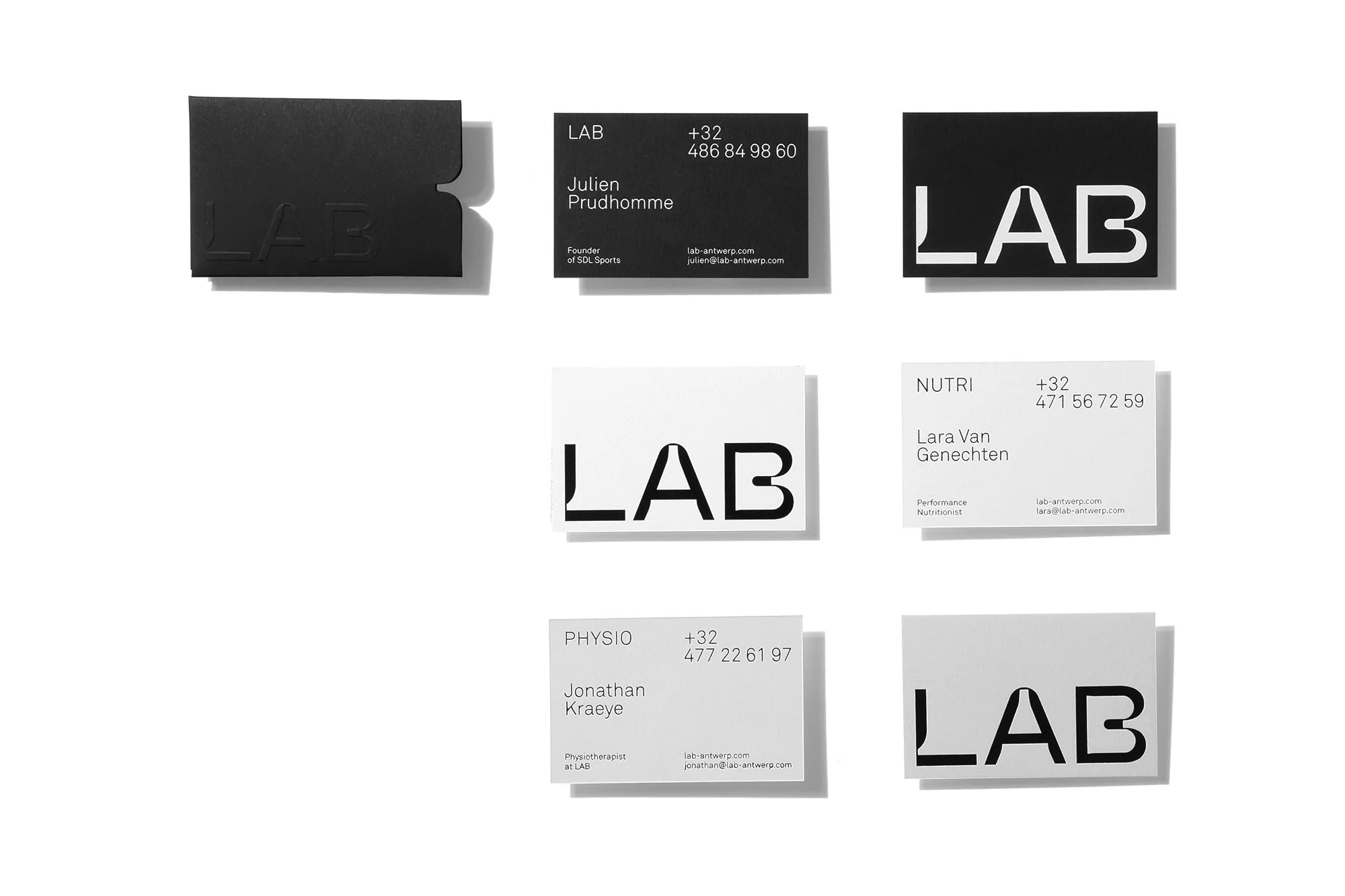 Collection of black and white business cards with the word 'LAB', phone numbers, and names against a plain, bright white background.