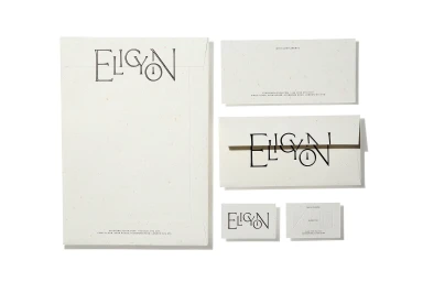 Stationery set featuring letterhead, envelopes, and business cards with Eligon branding on textured cream paper against white.