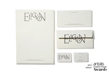 Flat lay of cream-coloured textured stationery items featuring minimalist black typography on paper against a white background.