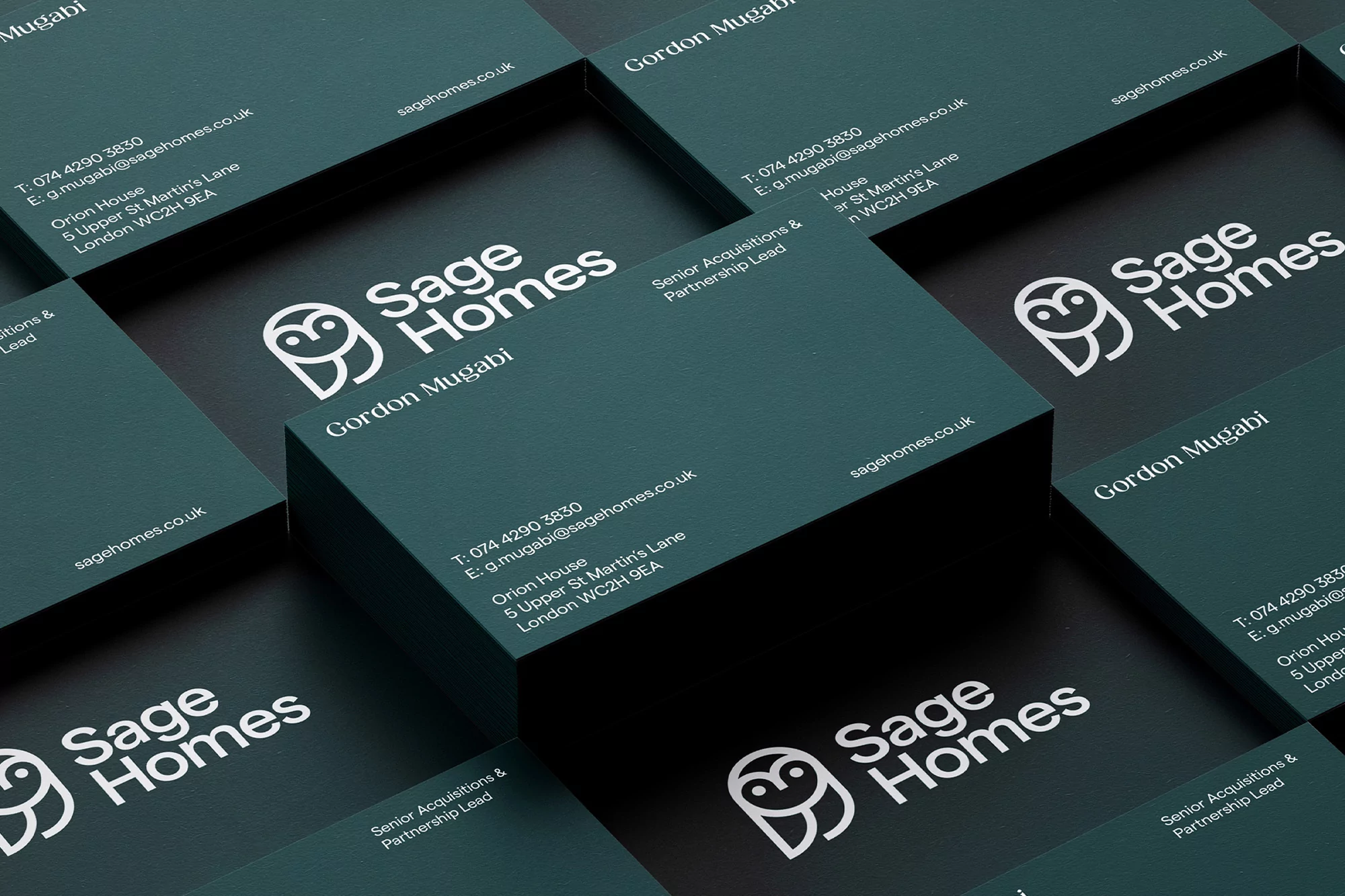 Stack of 'Sage Homes' business cards with logo, contact info, job title, and teal & black modern design, organized on a flat surface.