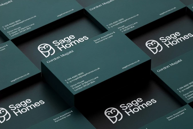 Stack of 'Sage Homes' business cards with logo, contact info, job title, and teal & black modern design, organized on a flat surface.