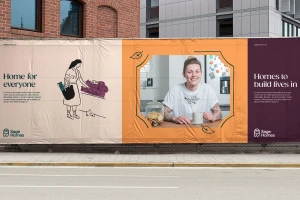 Outdoor construction fence banner featuring Sage Homes branding, graphic illustrations, and a centered portrait of a woman.