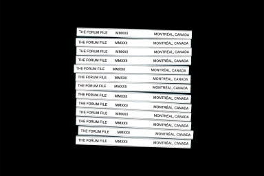 A stack of white magazine spines featuring black typography against a solid black background.