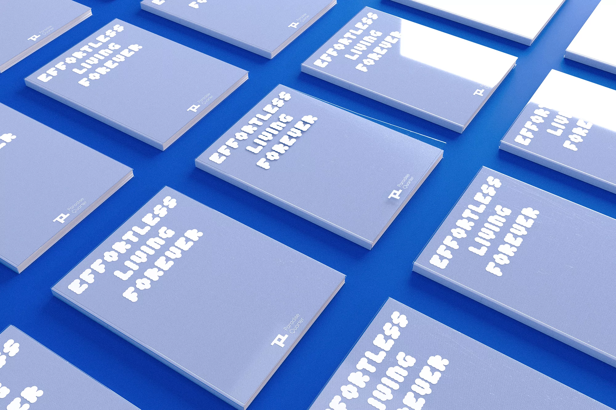 Several light-blue books titled 'Effortless Living Forever' arranged on a blue surface, creating a minimalist and visually appealing pattern.