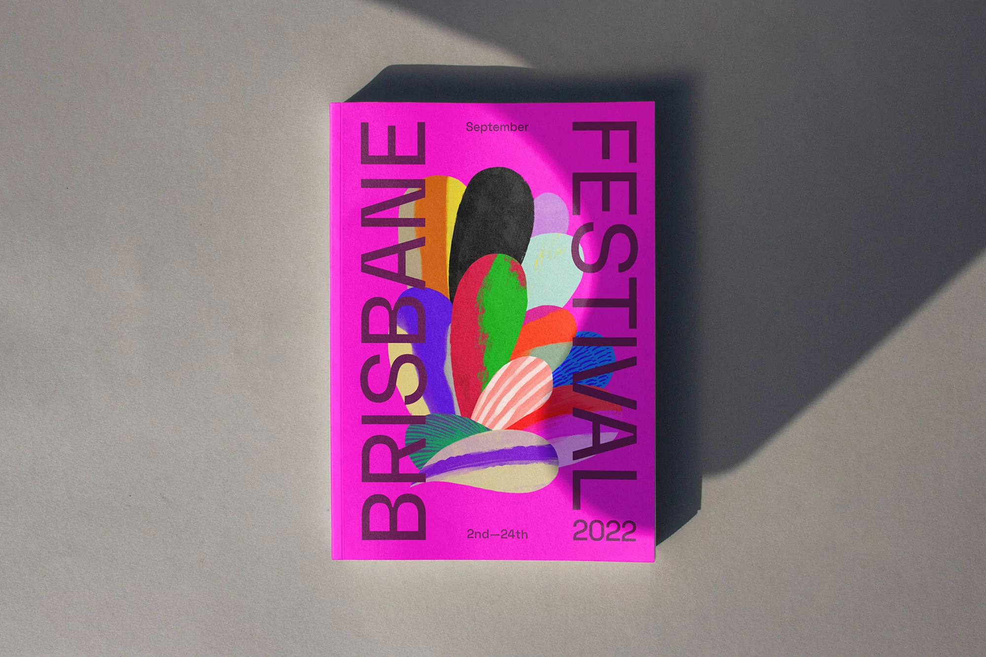 Promotional poster featuring an abstract, colorful design promoting the Brisbane Festival 2022, September 2nd-24th, on a light grey surface.