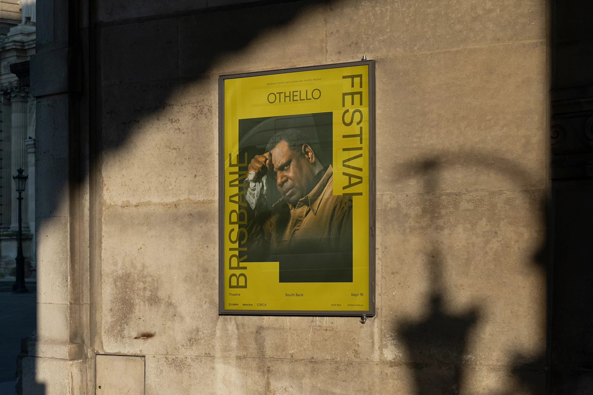Brisbane Festival poster featuring an African American man in the Othello play, mounted on an exterior building wall.