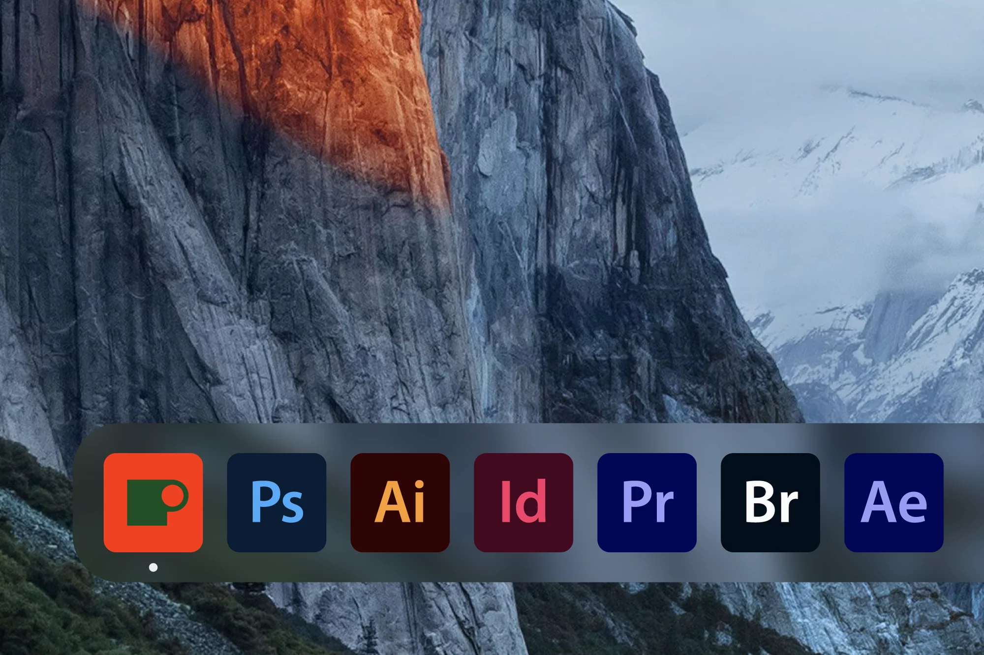 Desktop computer screen featuring Adobe software icons and snowy mountain range wallpaper; graphic design and nature photography.
