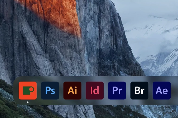 Desktop computer screen featuring Adobe software icons and snowy mountain range wallpaper; graphic design and nature photography.
