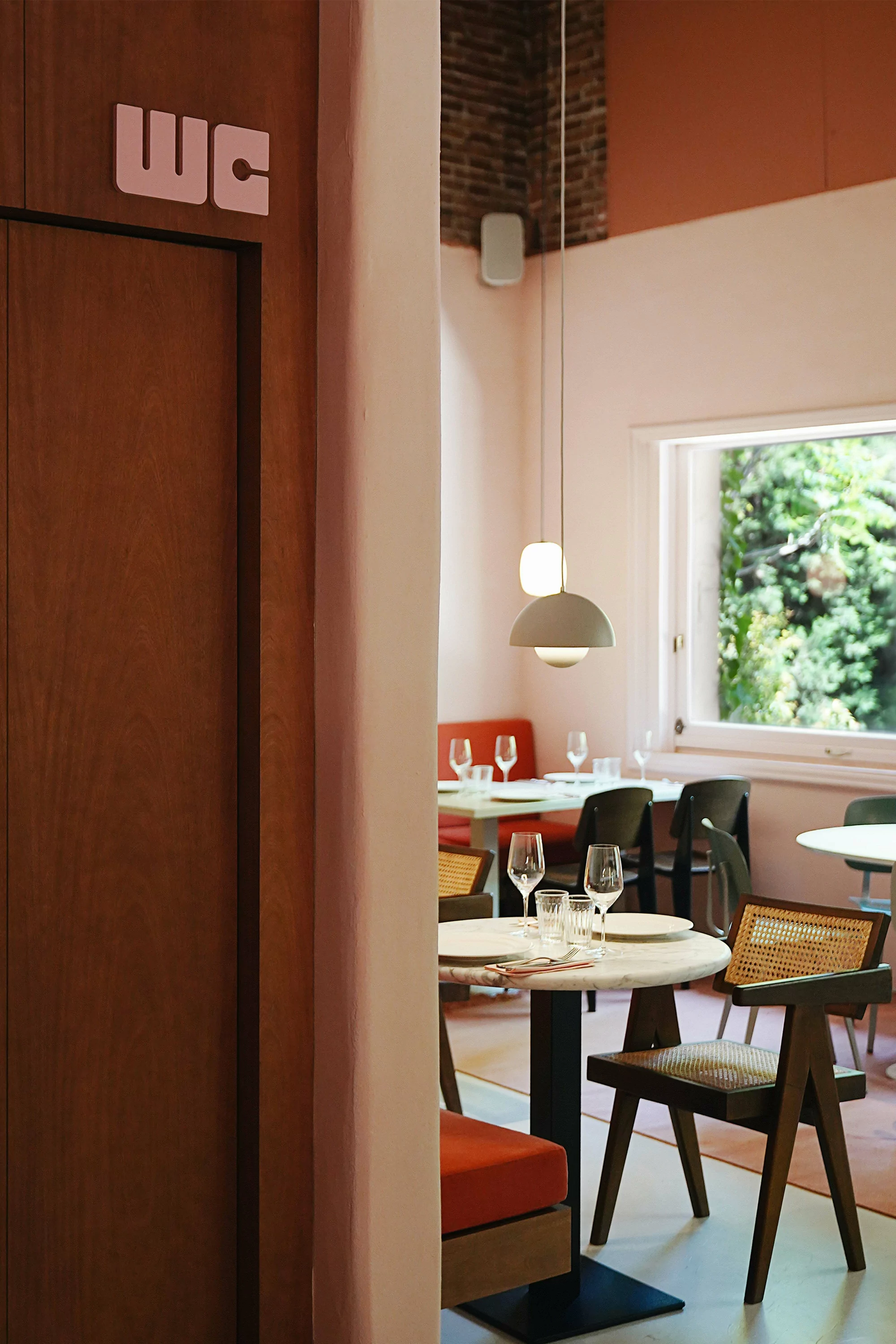 Restaurant interior view with tables, chairs, and pendant lights, showcasing a modern and inviting dining space.