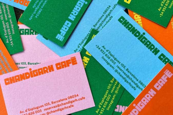 Pile of colorful business cards with Chandigarh Cafe contact information in orange, blue, green, and pink hues.