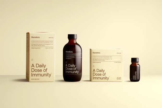 Manukora immunity supplement product lineup. Includes box and bottle formats in a neutral color palette against a light background.