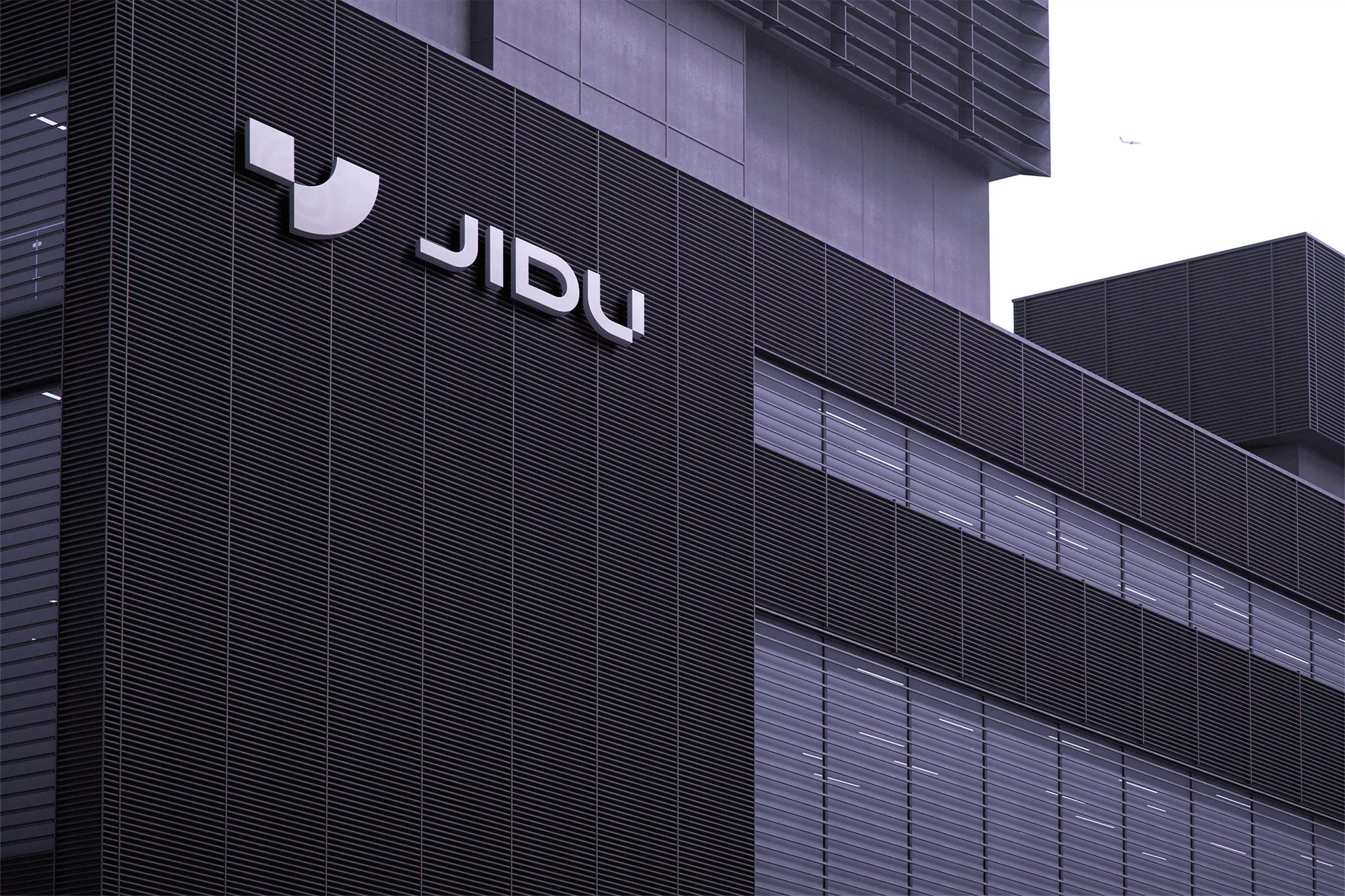 Exterior view of the JIDU headquarters building, showcasing its modern architectural design with the company logo prominently displayed.