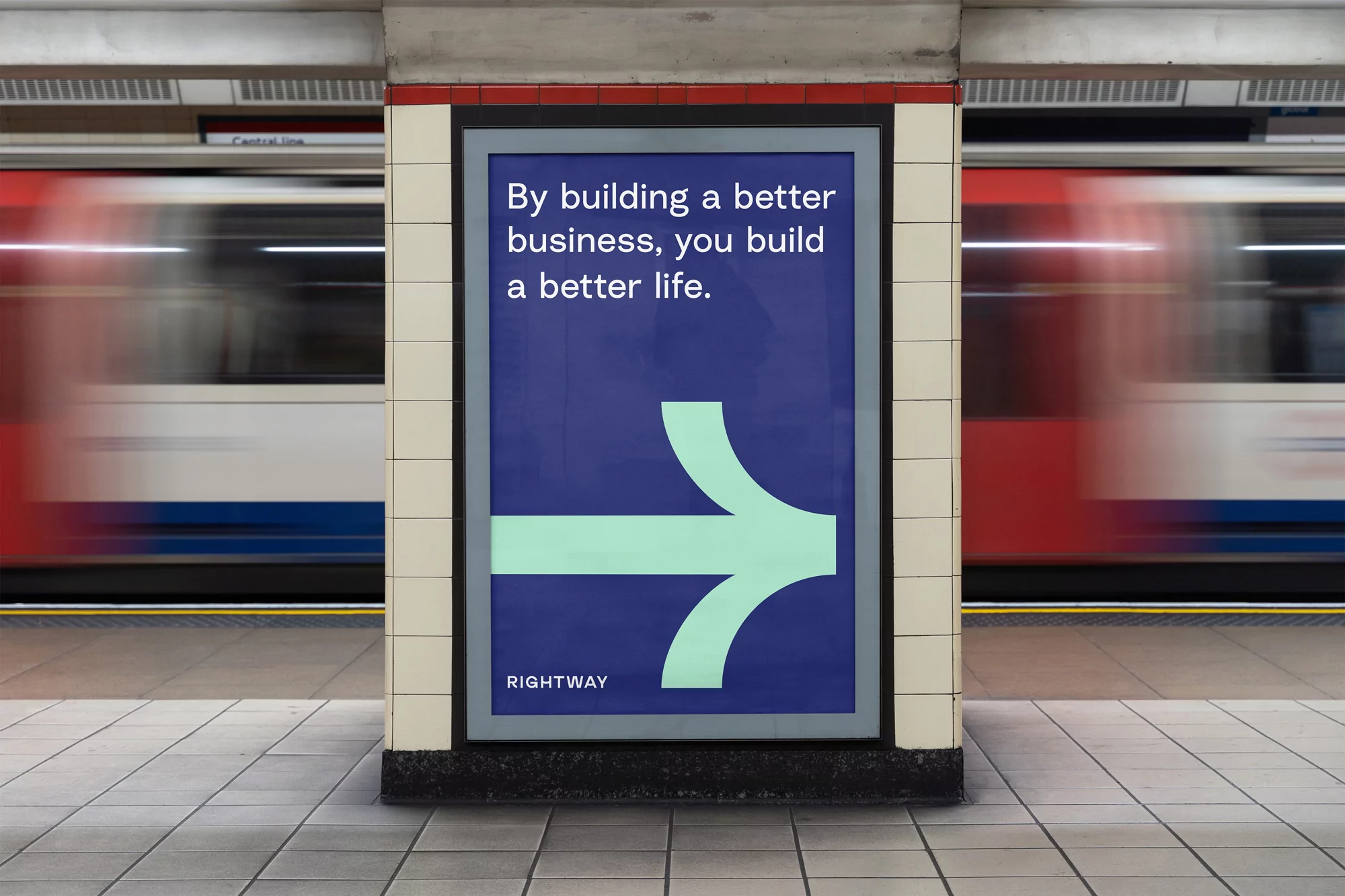 Advertisement poster in a subway station featuring a directional arrow and text 'By building a better business, you build a better life'.