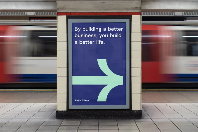 Advertisement poster in a subway station featuring a directional arrow and text 'By building a better business, you build a better life'.