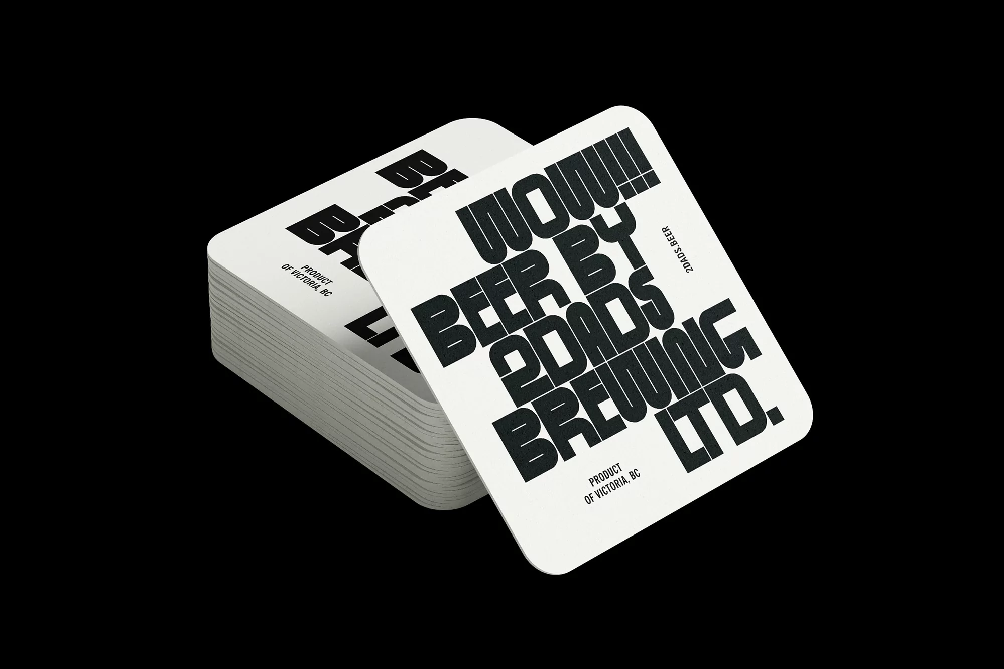 Stack of white square beer coasters with black typography, featuring the text 'WOW!!! BEER BY 20ADS BREWING LTD. PRODUCT OF VICTORIA, BC'