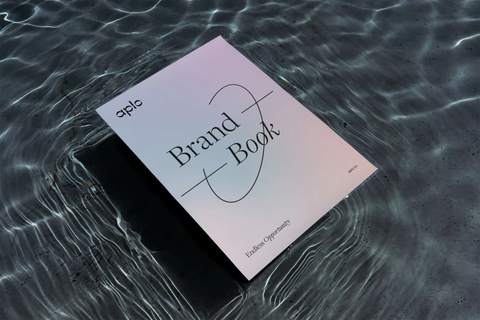 A brand book floats on a textured surface with shimmering water reflections, featuring the brand name 'aplo' and the phrase 'Endless Opportunity'.
