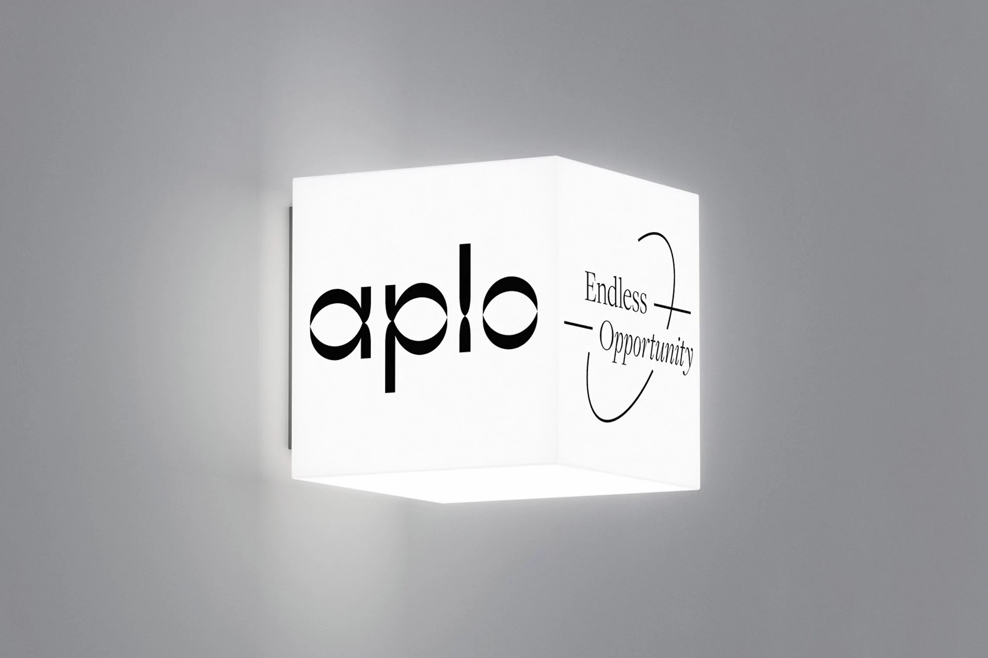 White cube with black text 'aplo' and 'Endless Opportunity' attached to a grey wall, minimalist design, indoor lighting.