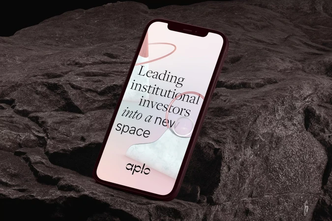 Mobile phone displays marketing text, placed on a textured rocky surface, creating a modern tech meets natural environment concept.