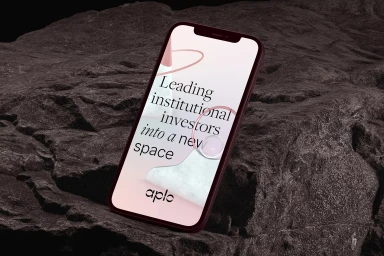 A dark smartphone displaying brand typography resting on a rugged dark stone texture background.
