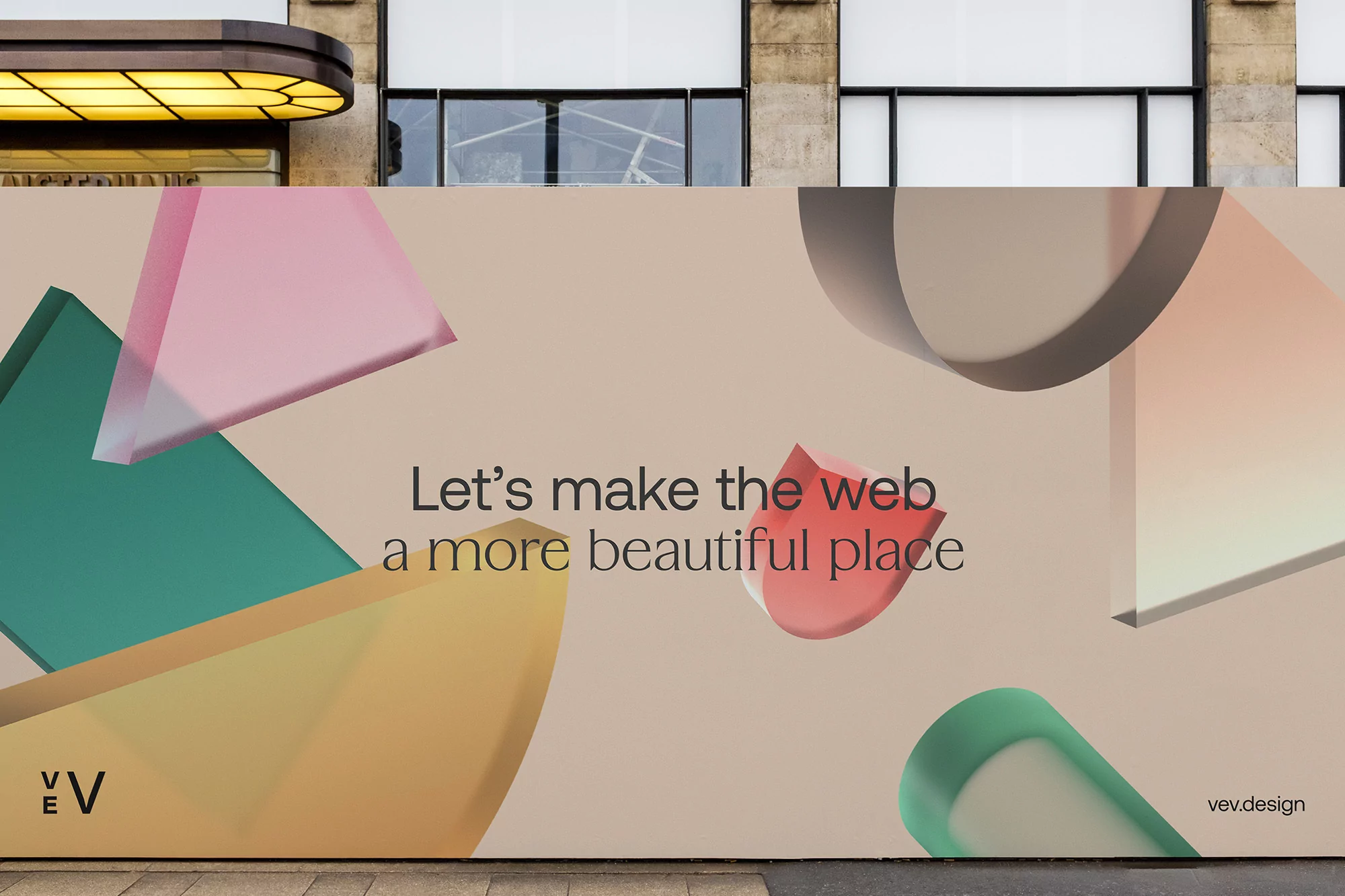 Colorful geometric shapes and text, 'Let's make the web a more beautiful place', adorn a building facade, promoting creative design.