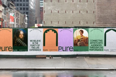Colorful promotional posters featuring typography and imagery pasted along a city construction barrier.