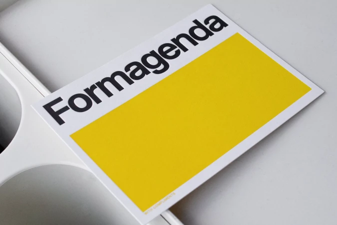 Formagenda brand identity card with black typography and yellow block resting on white surface