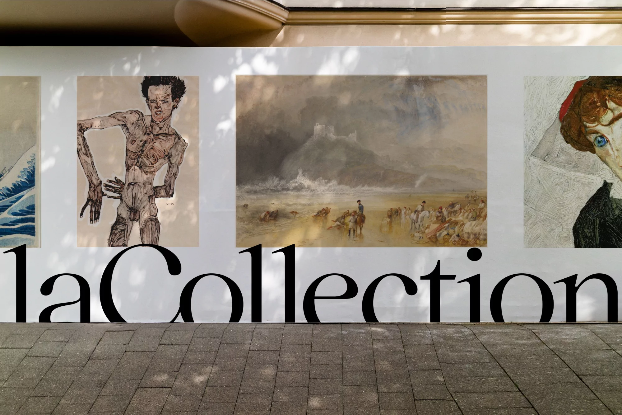 Outdoor display of framed fine art prints on a wall with the text "laCollection" in large black letters on a stone-paved surface.