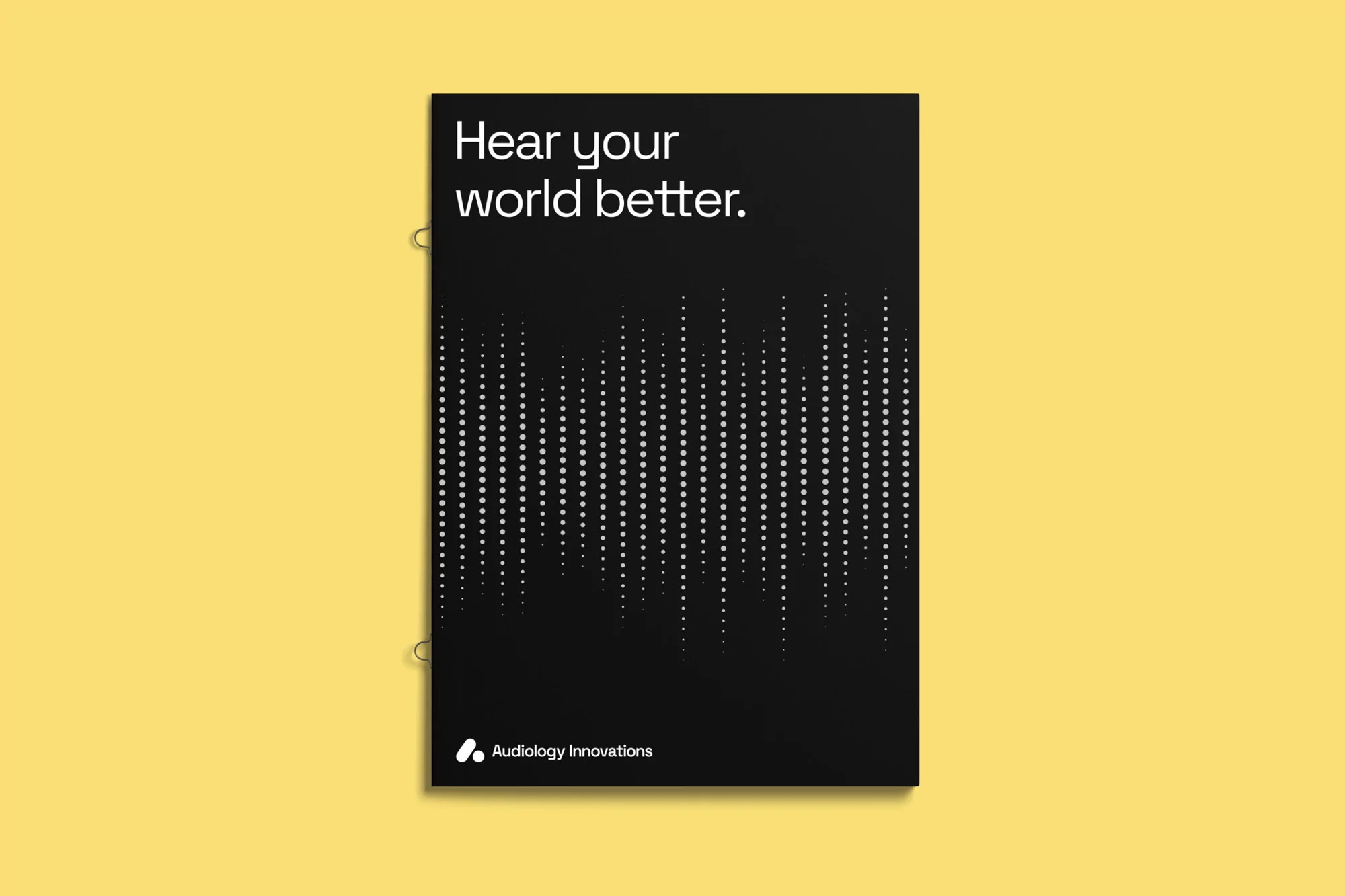 Promotional poster features the text 'Hear your world better' with a sound wave graphic on a black background, displayed on a yellow surface.
