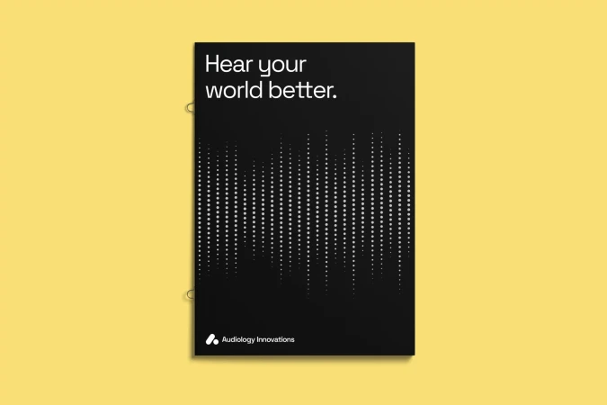 Promotional poster features the text 'Hear your world better' with a sound wave graphic on a black background, displayed on a yellow surface.