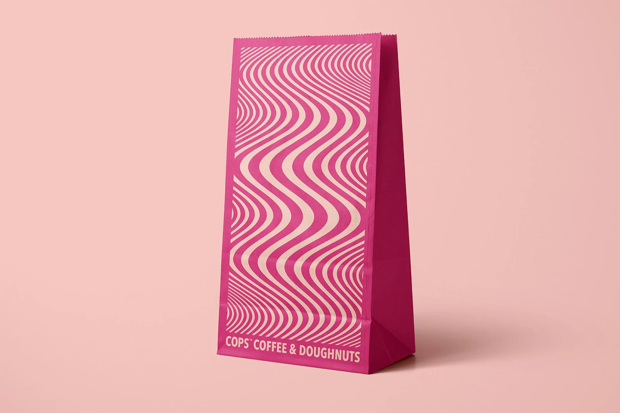Tall pink paper bag with a wavy line design, showcasing a modern and minimalist aesthetic against a matching light pink background.