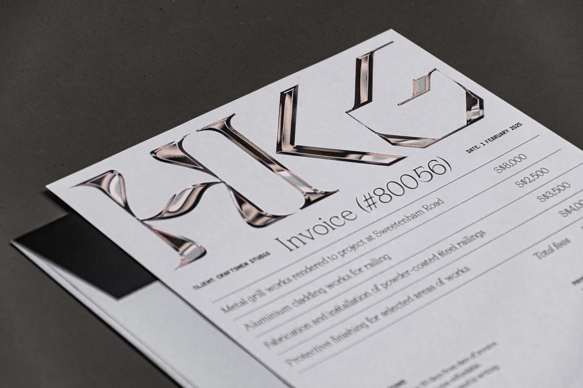 Close-up of a business invoice with chrome letterhead, set against a dark gray backdrop, highlighting the document's financial details.