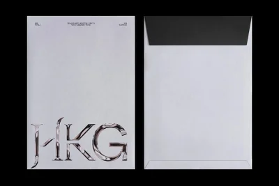 Front and back views of a white envelope featuring metallic custom typography and address details for HKG Metals branding