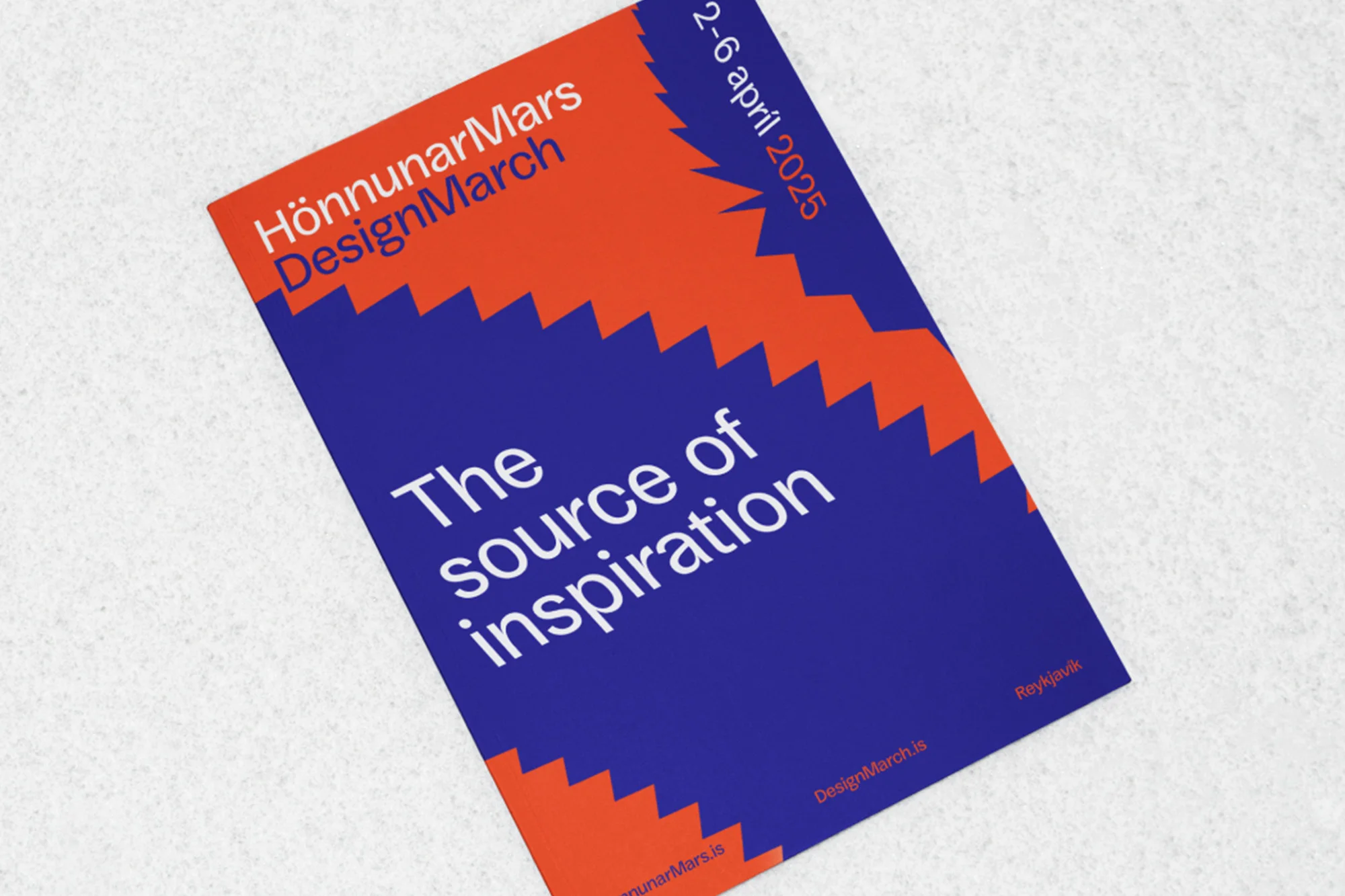 DesignMarch 2025 promotional material featuring red and blue graphic patterns and event details on a textured white surface.