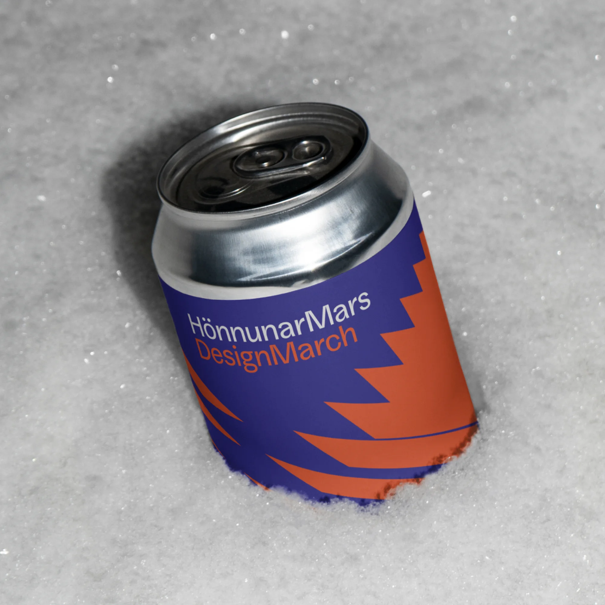 Silver aluminum can with colorful label isolated in a snowy environment, close up view, product shot, drink photography.