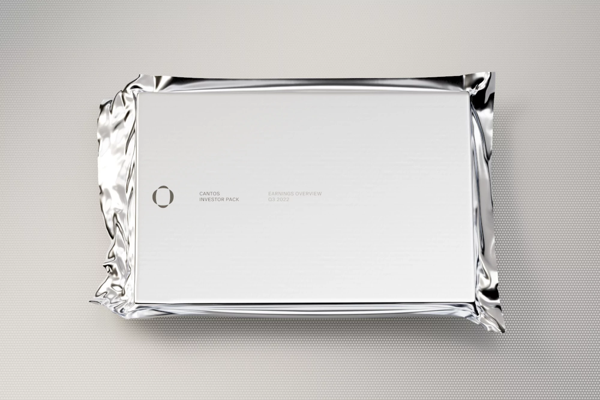 White box wrapped in shiny silver foil on grey dotted surface. The box has a logo and text that reads Cantos Investor Pack.