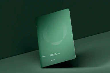 A dark green booklet titled Investment Portfolio Outline rests on a matching curved green surface against a solid green background.