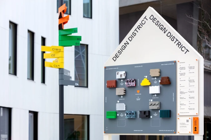 Architectural design district signage with material samples displayed outside a modern building; outdoor architectural reference.