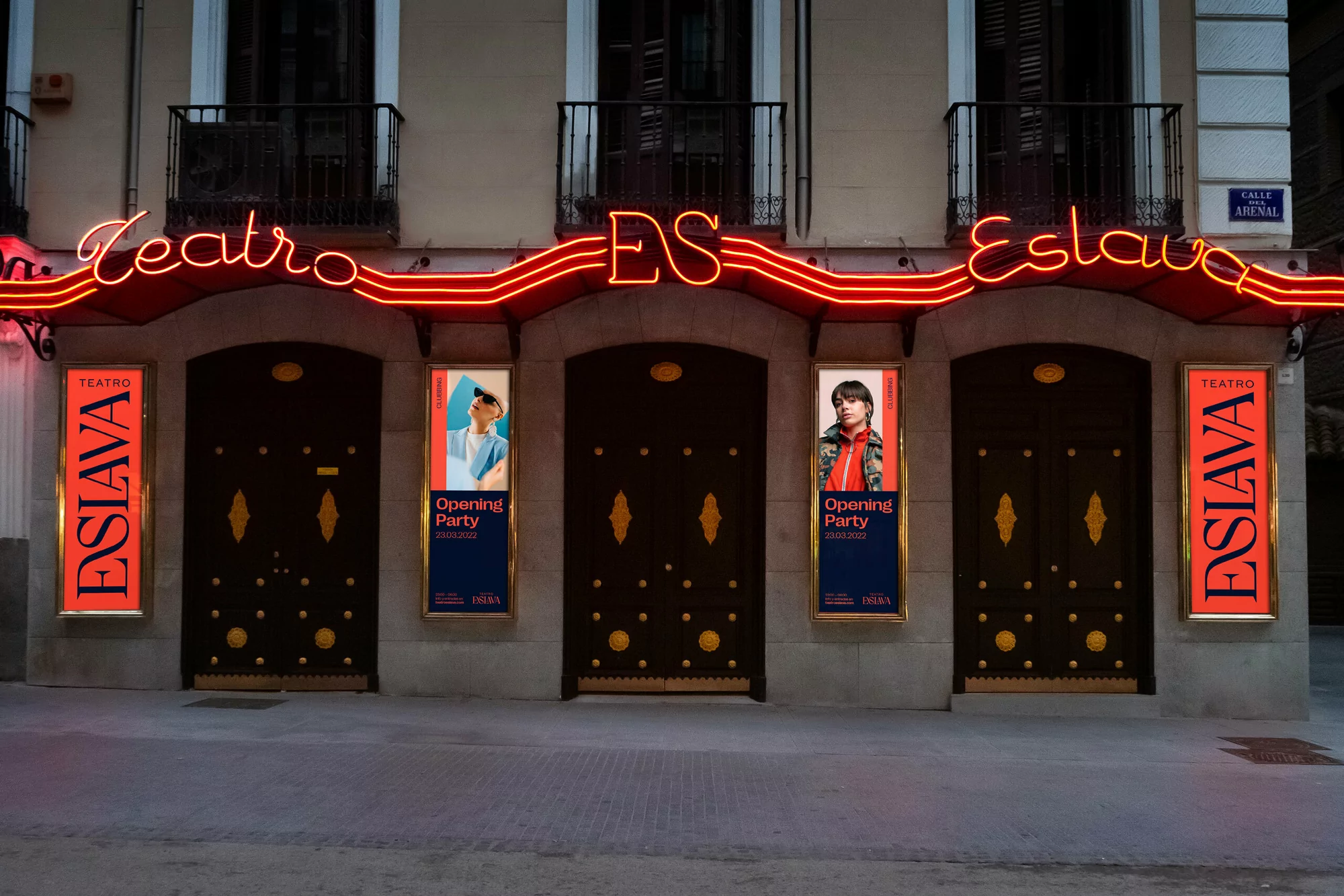 Facade of Teatro Eslava in Madrid, featuring ornate doors, balconies, and neon signage advertising 'Opening Party' event.
